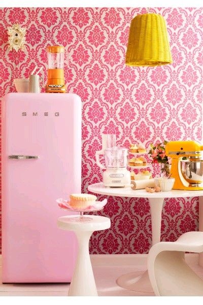 yellow and pink kithcen in retro style with pink fridge